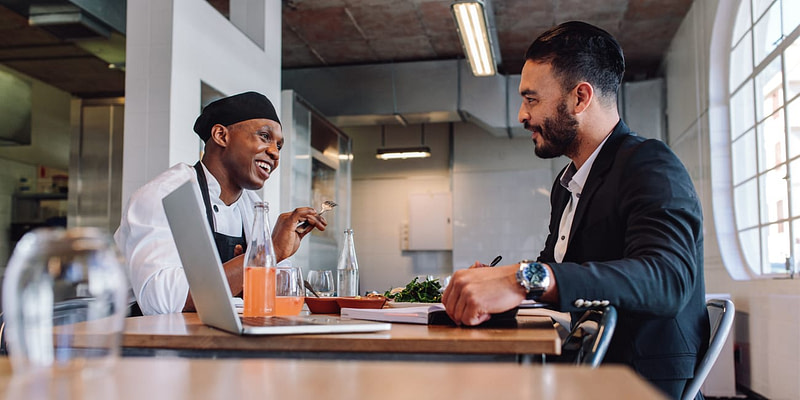 Smiling Chef & Executive Meeting Over Lunch