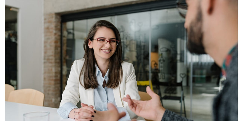 Young businesswoman conducting performance review with male professional