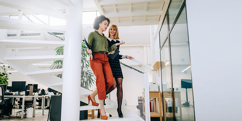 Two Coworkers Walking Down Spiral Stairs