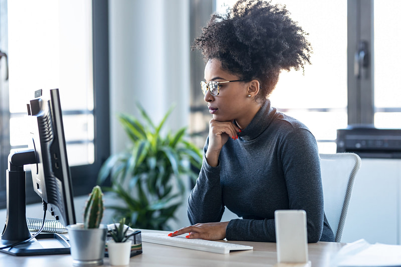 Shot of young afro business woman working while making video call about HCM systems