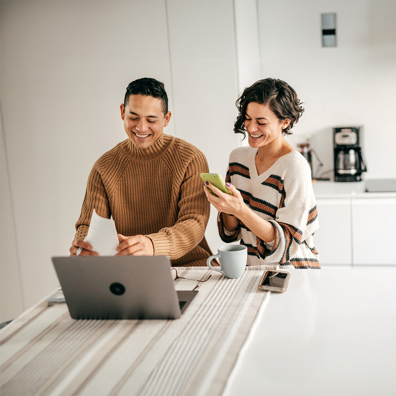 an attractive couple, happy, in front of a laptop