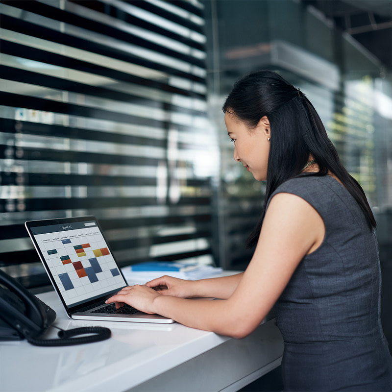 A happy woman working on a laptop computer