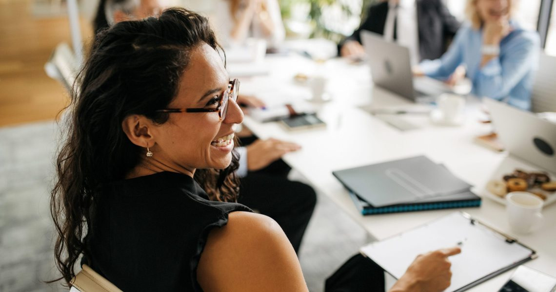 Hispanic Woman at Conference Table Laughing