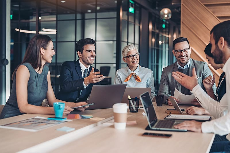 Mixed group of business persons sitting around the table