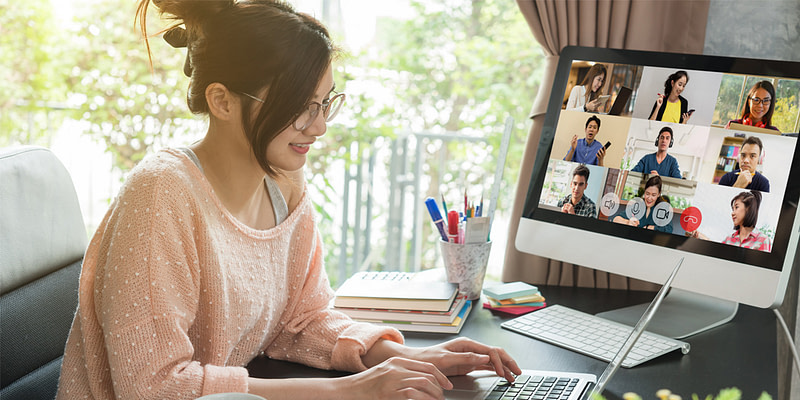 A young female professional video conferencing with her team while working remotely